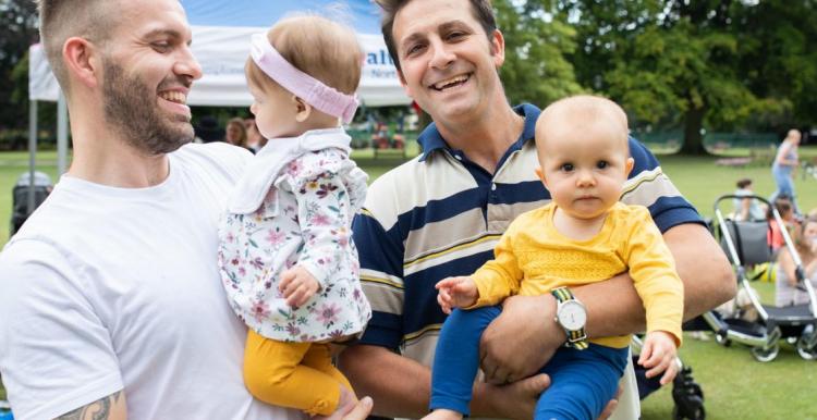 Smiling young dads with their babies in a park