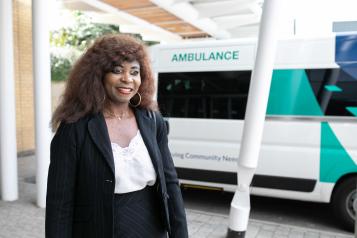 A woman standing in front of an ambulance