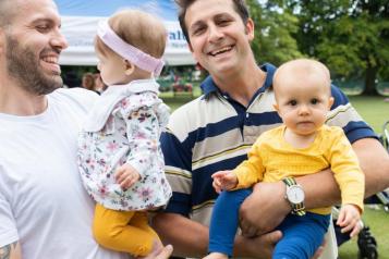 Smiling young dads with their babies in a park